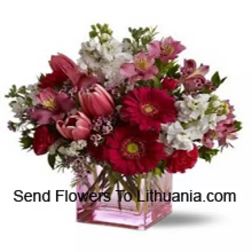 Rote Rosen, rote Tulpen und gemischte Blumen mit saisonalen Füllstoffen, wunderschön in einer Glasvase arrangiert