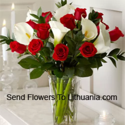 Rote Rosen und weiße Lilien mit etwas Farn in einer Glasvase